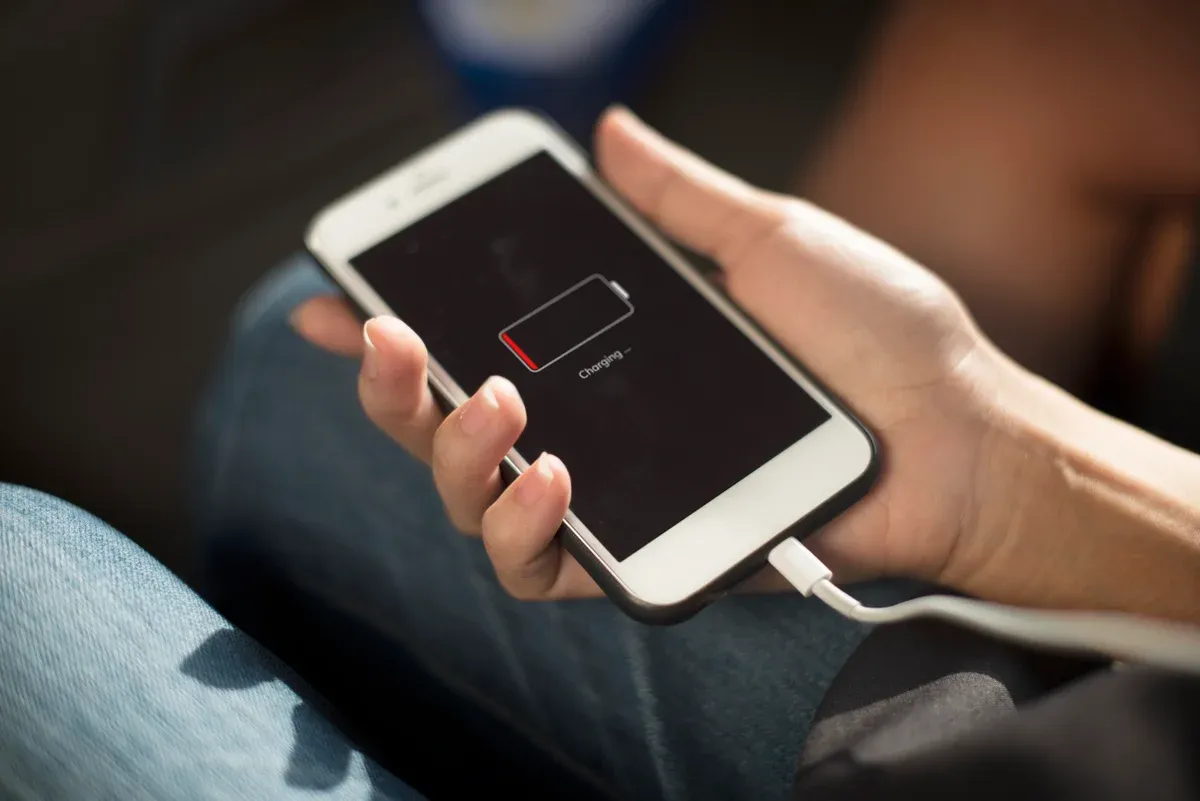 Celular conectado ao carregador com indicador de bateria baixa